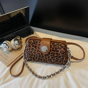 Détail d'un sac bandoulière léopard avec boucle en métal argenté et finitions en cuir marron