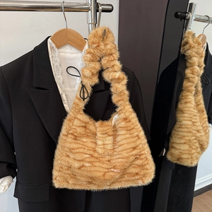 Detail der gestreiften Kunstpelz-Tasche mit flauschiger Textur und integriertem Griff