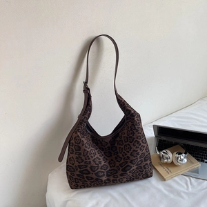 Detailed close-up of a leopard print hobo tote bag with adjustable shoulder strap and metal buckle