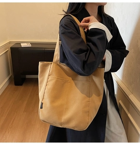 Detail view of khaki waterproof nylon tote bag showing the fashion label and side pocket