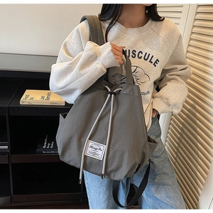 Detail view of the drawstring closure and grey canvas material on a stylish backpack