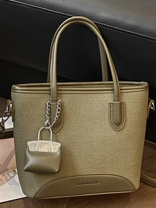 Fashionable earth-tone canvas and leather tote bag with a matching mini bag charm