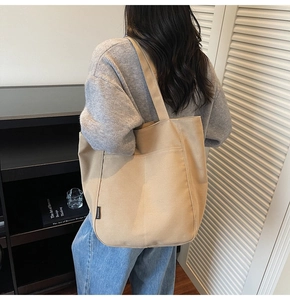 Detail view of khaki waterproof nylon tote bag with functional front pocket and logo