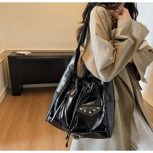 Detail of black large bucket bag with motorcycle style rivets and drawstring closure