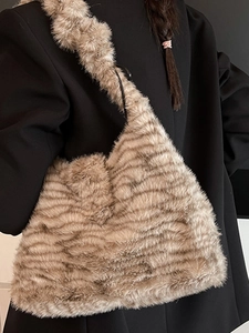Braune Leoparden-Plüschtasche mit Wellenmuster, getragen von Model im schwarzen Anzug