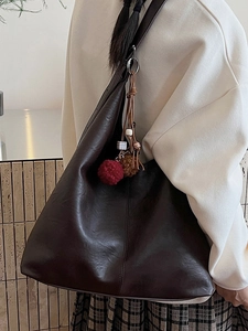 Large brown soft leather bucket shoulder bag with bohemian tassel and bead accents