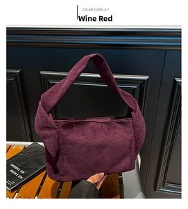 Détail du sac cabas en daim bordeaux avec un nœud décoratif sur la bandoulière