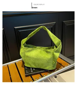 Détail du sac cabas en daim vert herbe avec une poignée nouée au design unique