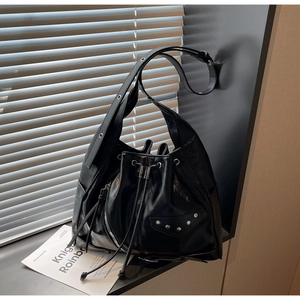 Detail of black motorcycle bucket bag with oil-wax leather texture and silver rivets