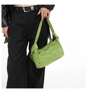 Gros plan détaillé d'un sac à bandoulière en daim vert avec un design de sangle nouée