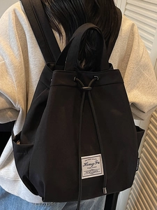 Minimalist black drawstring backpack with woven label for women's autumn fashion