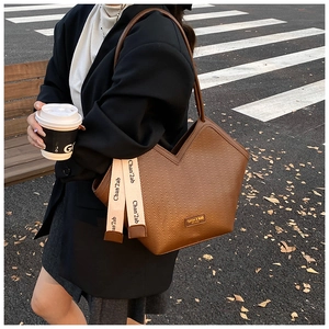 Detail view of brown vintage tote bag with herringbone pattern and V-shaped opening