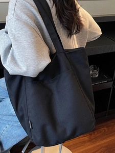 Black waterproof nylon tote bag with Fashion label for daily commuting and large capacity
