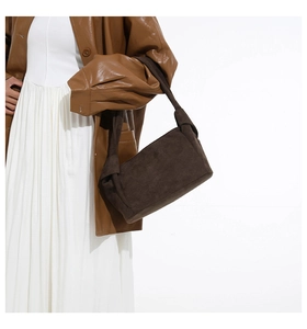 Détail du sac cabas en daim marron foncé avec un nœud décoratif sur la bandoulière