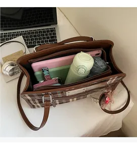 Spacious interior of brown plaid tote bag showing tablet, wallet, and accessories