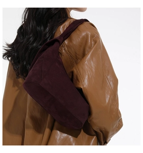 Détail d'un sac hobo en daim bordeaux montrant sa texture douce et sa forme élégante