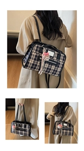 Detail view of vintage plaid tote bag with dark blue pattern and pink plush bear charm
