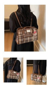 Detail of vintage brown plaid tote bag with leather straps and a cute plush bear charm