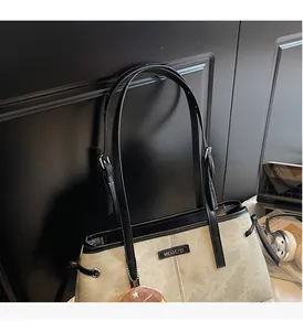Dettaglio della borsa tote kaki con manici regolabili in pelle nera e fibbie in metallo