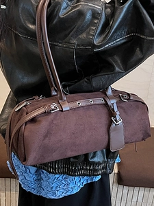 Minimalist brown suede cylinder underarm bag with retro buckle and rivet details for women