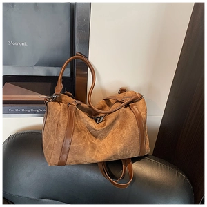Detail of dark brown vintage texture Boston bag with leather straps on a black cushion