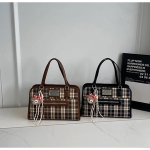 Close-up of British style plaid tote bags in brown and blue with plush bear charms