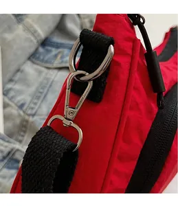 Detail of high-quality silver metal hook and durable black strap on the red canvas bag