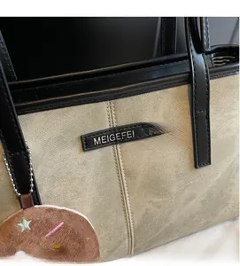 Dettaglio della borsa tote in tela con manici in pelle e ciondolo a stella in peluche