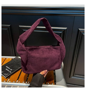 Détail de la large poignée nouée sur un sac cabas minimaliste en daim violet foncé