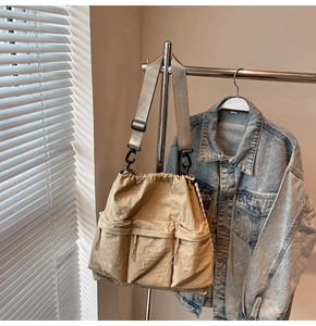 Detail of khaki nylon crossbody bag with three cargo pockets and adjustable shoulder strap