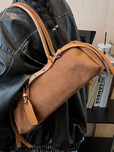 Caramel brown suede Boston barrel bag with leather strap shown on a model