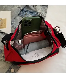 Macro shot showing the spacious red crossbody bag interior with phone and wallet