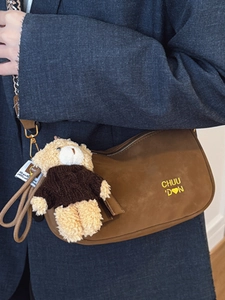 Borsa a tracolla a mezzaluna in camoscio marrone con ciondolo orsetto e logo