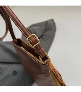 Gros plan du fermoir doré vintage et détails à franges sur sac seau en cuir synthétique