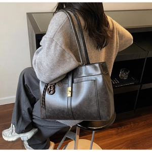 Détail du cabas en cuir vintage avec fermoir en métal doré et pendentif décoratif en B