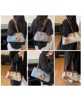 Borsa a tracolla retrò in tessuto denim con cinturini in pelle marrone e ciondolo donut