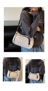 Close-up of minimalist cream nylon crescent crossbody bag with adjustable strap details
