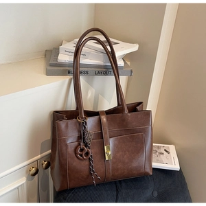 Détail du sac cabas vintage marron avec fermoir doré tournant et pendentif en cœur