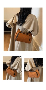 Detail of caramel nylon crossbody bag with black trim and 'Beautiful is Found Within' text