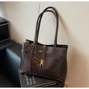 Détail d'un sac cabas marron vintage avec fermoir doré et texture cuir rétro