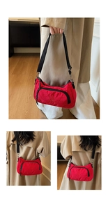 Detail view of red nylon crossbody bag with black zipper and adjustable fabric strap
