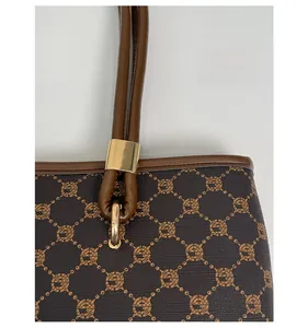 Detail of high-quality gold hardware and plaid monogram print on coffee tote bag