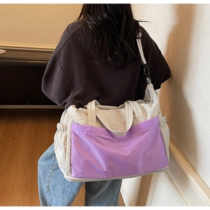 Detail view of large nylon tote bag with purple checkered pocket and adjustable strap