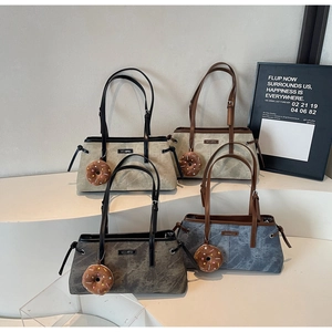 Dettaglio di borse tote minimaliste opache in grigio e kaki con ciondoli a ciambella
