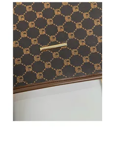 Detail of scratch-resistant brown monogram leather tote bag with gold metal hardware
