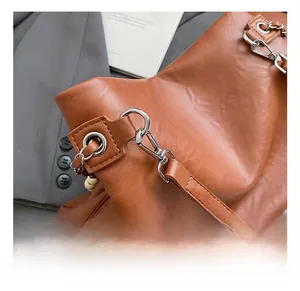 Close-up of brown faux leather bag featuring a vintage texture and silver metal hook