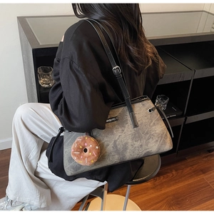 Dettaglio della borsa tote vintage grigio scuro con pelle invecchiata e ciondolo