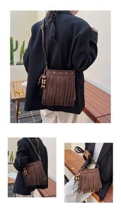 Détails du sac seau marron en daim avec rivets en forme d'étoile dorée et longues franges