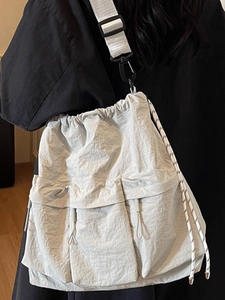 Fashionable beige nylon crossbody bag with drawstring closure and large cargo pockets