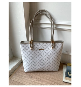 Detail view of large tote bag with gray geometric pattern and khaki faux leather straps